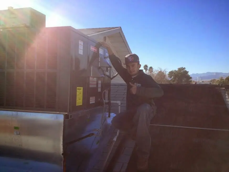 HVAC technician performing Boiler Repair on a rooftop unit in Lockport